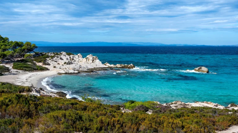 Côte de la mer Égée avec de la verdure autour des rochers et des buissons