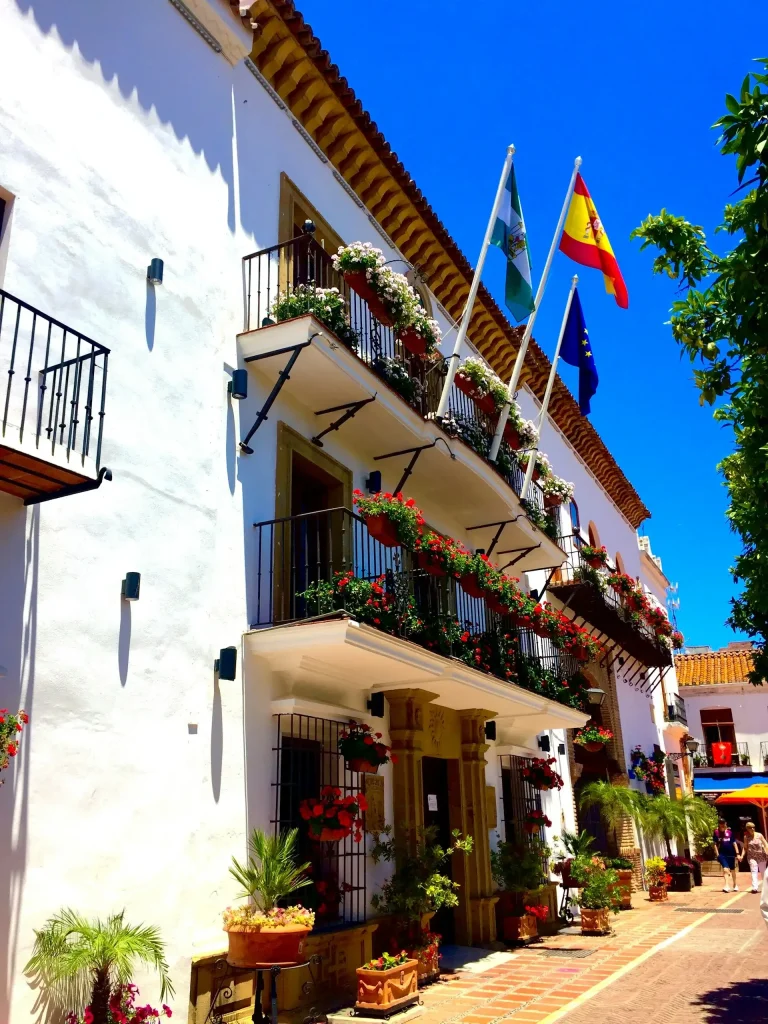 Bâtiment avec des drapeaux et des fleurs sur son balcon pendant la journée