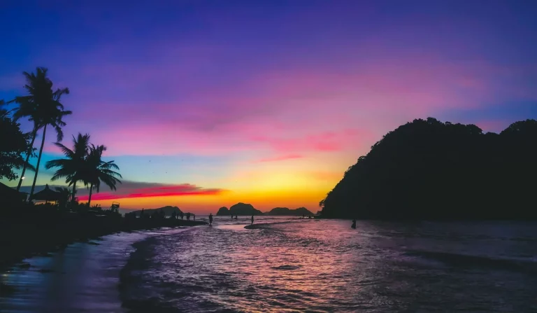 Silhouette de personnes sur la plage au coucher du soleil.